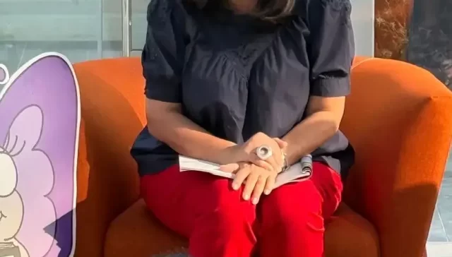 Mother-turned-author reading her children’s book to young kids at a community storytelling event, passing on a renewed love for stories and imagination