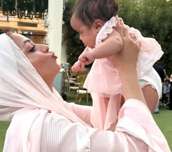 Mother holding her newborn up in the air