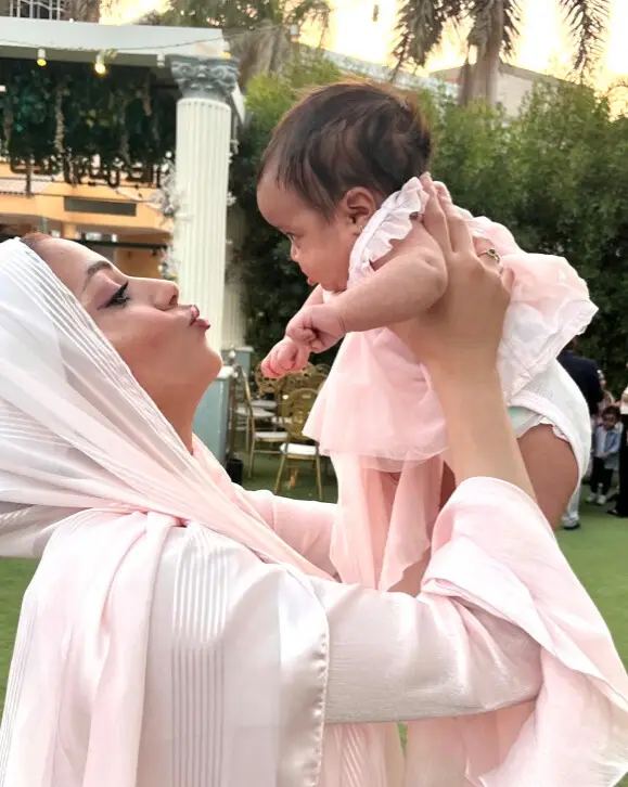 Mother holding her newborn up in the air